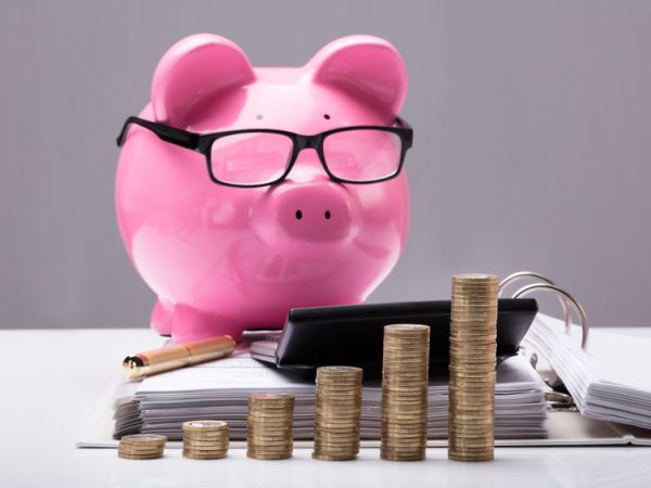 Stacked Coins And Document In Front Of Piggy Bank Stacked Coins And Document In Front Of Piggy Bank